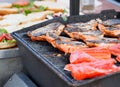 Salmon grilled on barbecue, bans for sandwich in the background Royalty Free Stock Photo