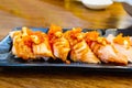 Salmon grilled with cheese over Shrimp Roe on top in black bowl of Japanese food Royalty Free Stock Photo