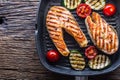 Salmon. Grilled fish salmon. Grilled salmon steak in grill pan on rustic wooden table Royalty Free Stock Photo
