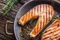 Salmon. Grilled fish salmon. Grilled salmon steak in roasted pan on rustic wooden table Royalty Free Stock Photo