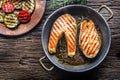 Salmon. Grilled fish salmon. Grilled salmon steak in roasted pan on rustic wooden table Royalty Free Stock Photo