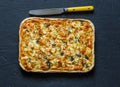 Salmon, leek, spinach, cheese puff pastry pie on dark background