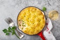 Salmon, mashed potatoes and vegetables casserole in enamel cast iron pan