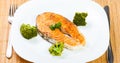 Salmon meat with delicious broccoli on white plate