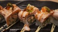 Salmon Oyako Spicy roll consist of crispy salmon skin is wrapped with sushi rice, topped with half broiled Aburi Salmon with spicy