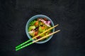 Salmon Poke Salad with spinach and basil. Homemade food. The concept of a tasty and healthy meal. Dark stone background.