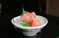 Salmon raw slice or salmon sashimi in Japanese style fresh serve on ice with fresh wasabi on black table