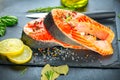 Salmon. Raw Trout Red Fish Steak served with Herbs and Lemon and olive oil on slate. Cooking Salmon, sea food. Healthy eating Royalty Free Stock Photo