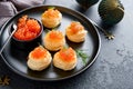 Salmon red caviar toast. Christmas canape or toast with red caviar on black plate on dark background. Idea to xmas snack. Gourmet Royalty Free Stock Photo