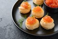 Salmon red caviar toast. Christmas canape or toast with red caviar on black plate on dark background. Idea to xmas snack. Gourmet Royalty Free Stock Photo