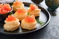 Salmon red caviar toast. Christmas canape or toast with red caviar on black plate on dark background. Idea to xmas snack Royalty Free Stock Photo