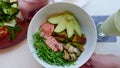 Salmon Salad with Avocado, Zucchini, Top View, Hands Rotating. Fish Poke Bowl