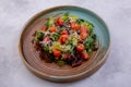 Salmon Salad. Salted salmon, mixed salad, grapefruit, Parmesan cheese, pine nuts in the dark plate. European cuisine. The work of