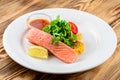 salmon with salad and vegetables - dish on a wooden background Royalty Free Stock Photo