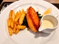 salmon slice grilled on green spanish cream salad sauce in white dish. fried potato chips serve side smoke fish Royalty Free Stock Photo