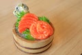 Salmon slices Sashimi fillet in wood bucket on wood table background. Traditional Japanese food Royalty Free Stock Photo