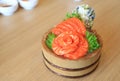 Salmon slices Sashimi fillet in wood bucket on wood table background. Traditional Japanese food Royalty Free Stock Photo