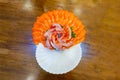 Salmon slices was decorated to cake shape on ice in white bowl