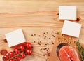 Salmon steak, cherry tomatoes, capsules, white boxes with no logo, black and red peppercorns, salt on wooden background