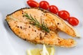 Salmon steak with herbs and spices rosemary lemon tomato on plate background - Close up cooked salmon fish fillet steak seafood Royalty Free Stock Photo