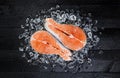 Salmon steak on ice on black wooden table top view Royalty Free Stock Photo