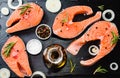 salmon steak, pepper and salt, herbs on black stone concrete table, copy space top view Royalty Free Stock Photo