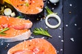 salmon steak, pepper and salt, herbs on black stone concrete table, copy space top view Royalty Free Stock Photo