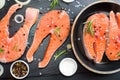 salmon steak, pepper and salt, herbs on black stone concrete table, copy space top view Royalty Free Stock Photo