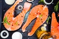salmon steak, pepper and salt, herbs on black stone concrete table, copy space top view Royalty Free Stock Photo