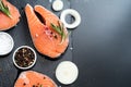 salmon steak, pepper and salt, herbs on black stone concrete table, copy space top view Royalty Free Stock Photo