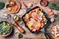 Salmon steak with vegetables on iron grill pan, bowl with kale salad, nuts, organic vegetable and kitchen utensils over wooden Royalty Free Stock Photo