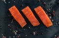 Salmon steakes with pepper and salt grains on the black board