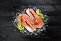 Salmon steaks on black wooden table background Royalty Free Stock Photo