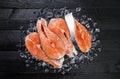 Salmon steaks on black wooden table top view Royalty Free Stock Photo