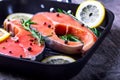 Salmon steaks in a grill pan with lemon, herbs and spices Royalty Free Stock Photo