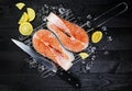Salmon steaks on ice on black wooden table top view Royalty Free Stock Photo
