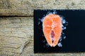 Salmon steaks on ice on black wooden table top view. Fish food concept. Copy space Royalty Free Stock Photo