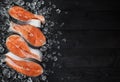 Salmon steak on ice on black wooden table top view, Fish food concept. Copy space Royalty Free Stock Photo