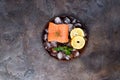 Salmon steaks on ice with lemon slice on wooden plate. Lean proteins. Royalty Free Stock Photo