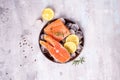 Salmon steaks on ice with lemon slice on wooden plate. Lean proteins. Royalty Free Stock Photo