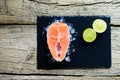 Salmon steaks with lime on ice on black wooden table top view. Fish food concept. Copy space Royalty Free Stock Photo