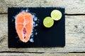 Salmon steaks with lime on ice on black wooden table top view. Fish food concept. Copy space Royalty Free Stock Photo