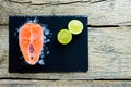 Salmon steaks with lime on ice on black wooden table top view. Fish food concept. Copy space Royalty Free Stock Photo