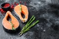 Salmon steaks with rosemary and pink pepper. Raw Organic fish. Black background. Top view. Copy space Royalty Free Stock Photo