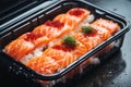 salmon sushi in a plastic container on a table