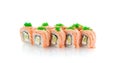 Salmon sushi roll with avocado, green tobiko and spice sauce isolated