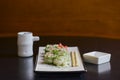 Salmon sushi rolls served on a white plate with ginger and wasabi and soy sauce in a restaurant table. Japanese cuisine. Royalty Free Stock Photo