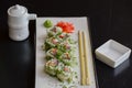 Salmon sushi rolls served on a white plate with ginger and wasabi and soy sauce in a restaurant table. Japanese cuisine. Royalty Free Stock Photo