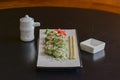 Salmon sushi rolls served on a white plate with ginger and wasabi and soy sauce in a restaurant table. Japanese cuisine. Royalty Free Stock Photo