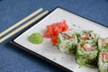 Salmon sushi rolls served on a white plate with ginger and wasabi and soy sauce in a restaurant table. Japanese cuisine. Royalty Free Stock Photo